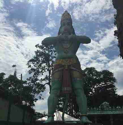 Large statue of a green monkey at entrance batu caves